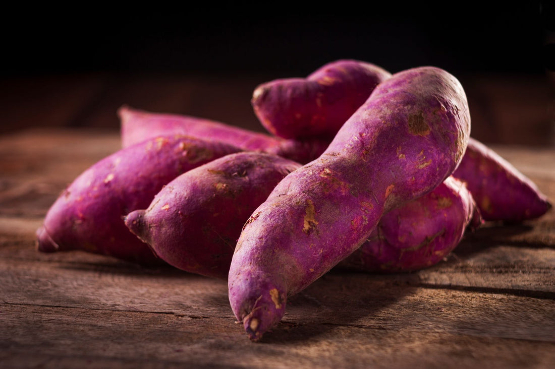 Ube violet en gros plan sur une surface en bois clair, tubercule brut aux antioxydants naturels