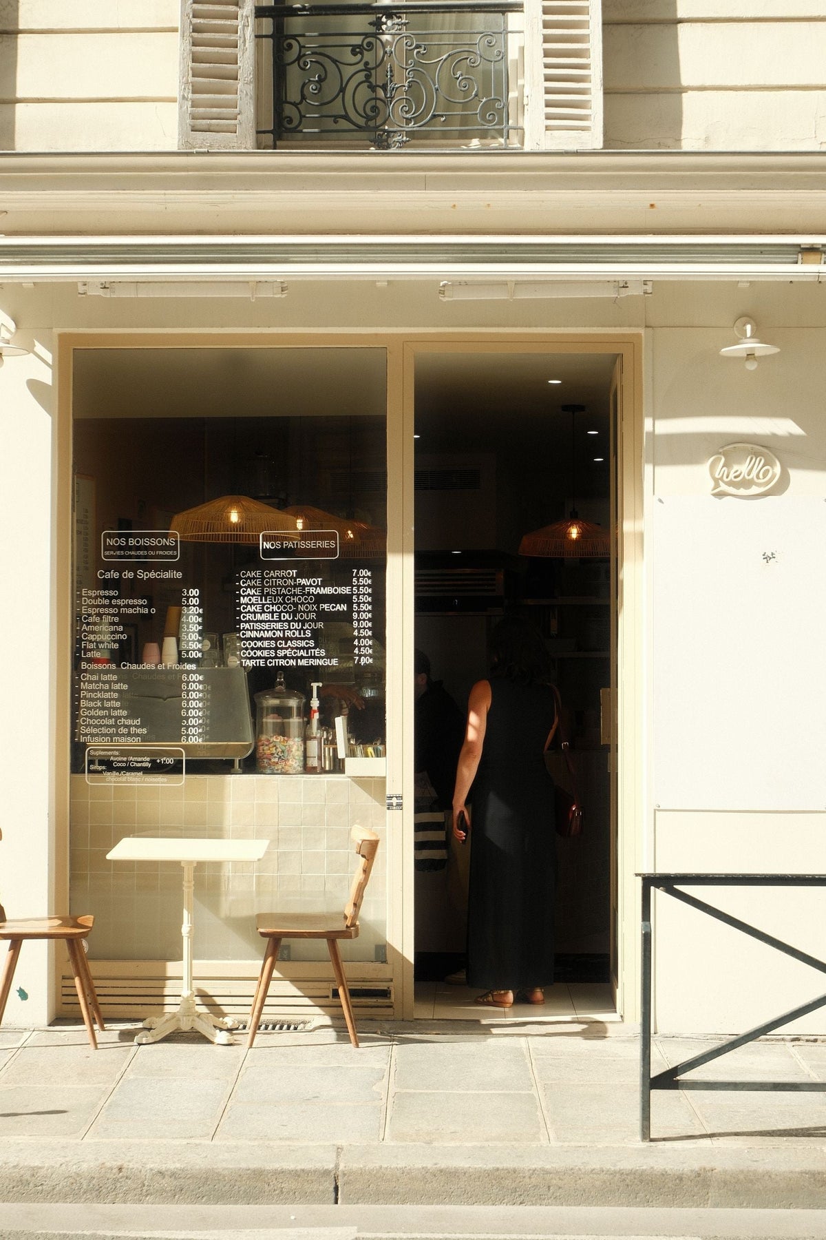 Devanture chaleureuse d'un café indépendant parisien avec sa carte affichée en vitrine, ambiance de quartier authentique