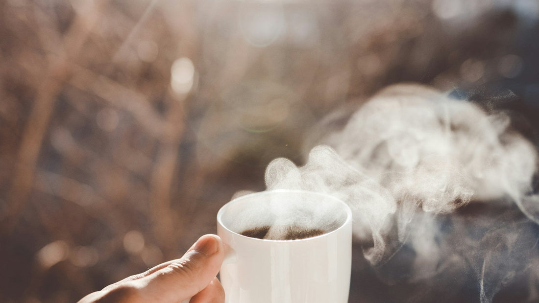 Personne tenant une tasse de café chaud le matin
