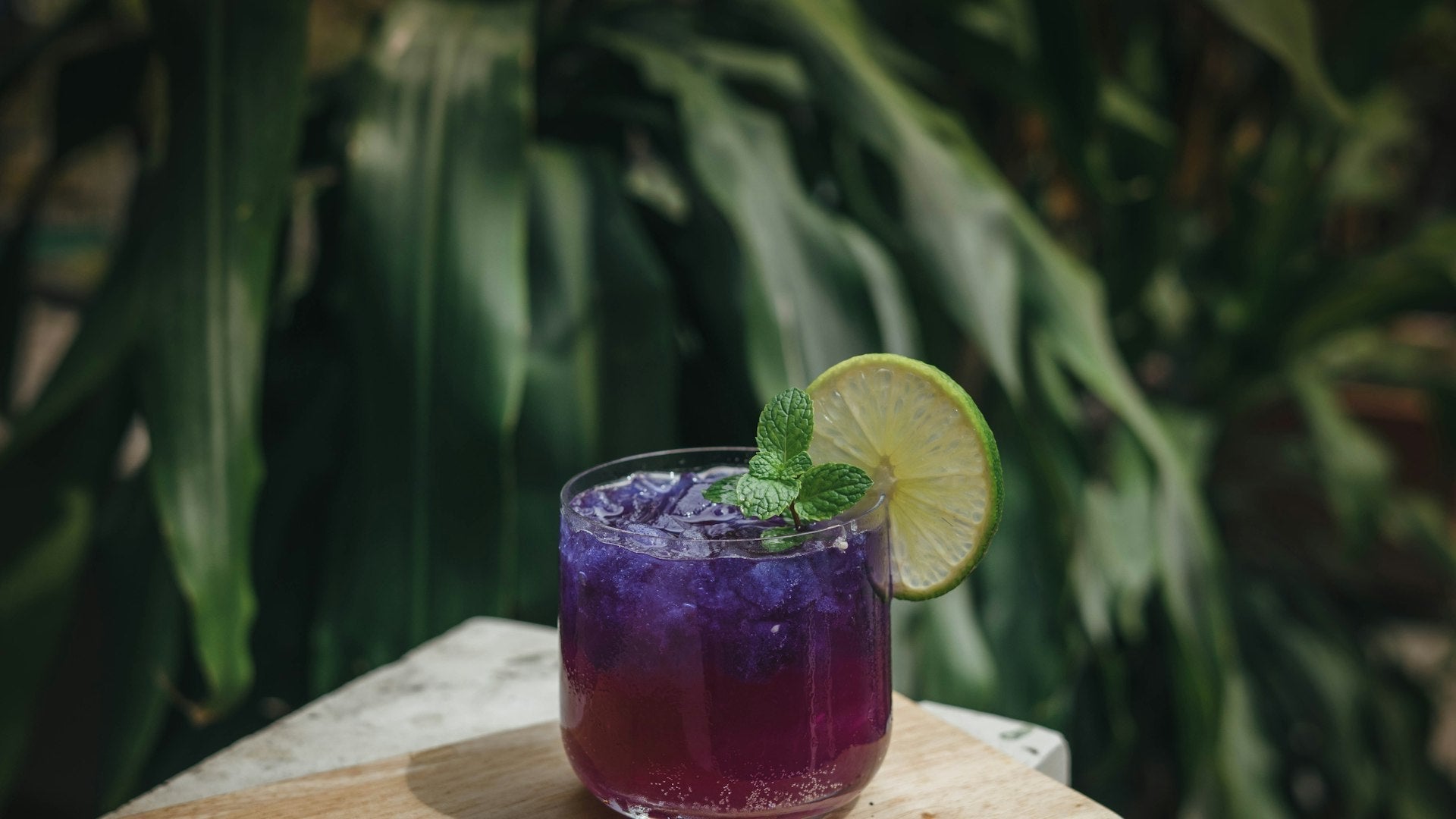 Boisson fraîche violette glacée avec citron vert et menthe, boisson healthy d'été
