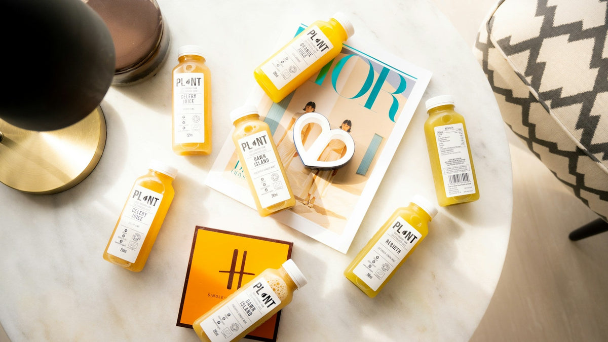Bouteilles de boissons bien-être colorées posées sur une table à côté d'un magazine, illustrant les tendances food & drink 2026