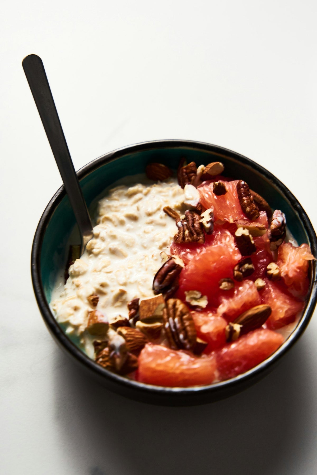 Bol de porridge à l'avoine garni de fruits frais et d'oléagineux, symbole d'un petit-déjeuner équilibré et énergisant